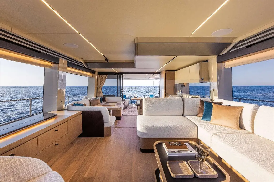 Luxurious yacht interior with modern furnishings, large windows showcasing the sea, and a stylish seating area.